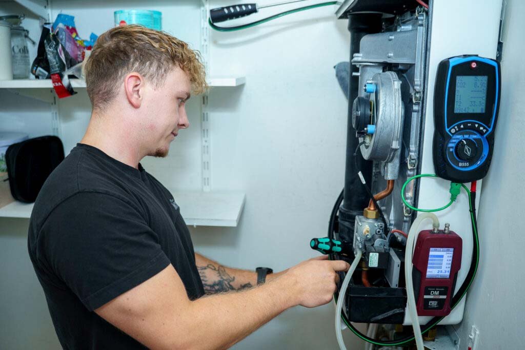 Loodgieter die de CV-ketel installatie onderhoudt